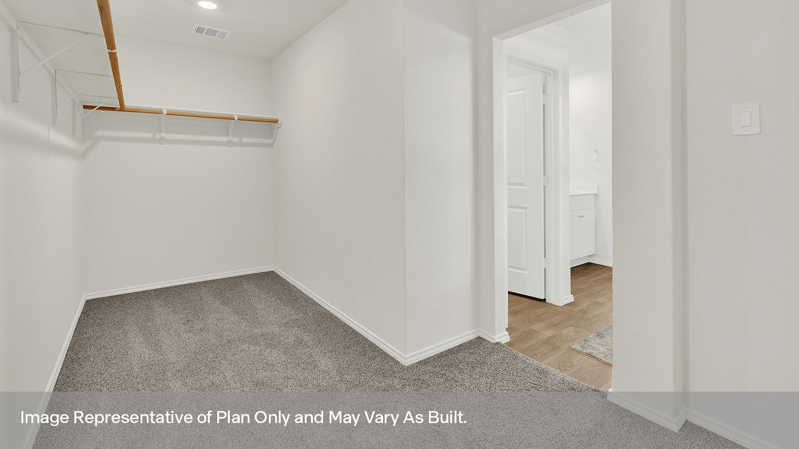 Closet with carpeting and wooden shelving.