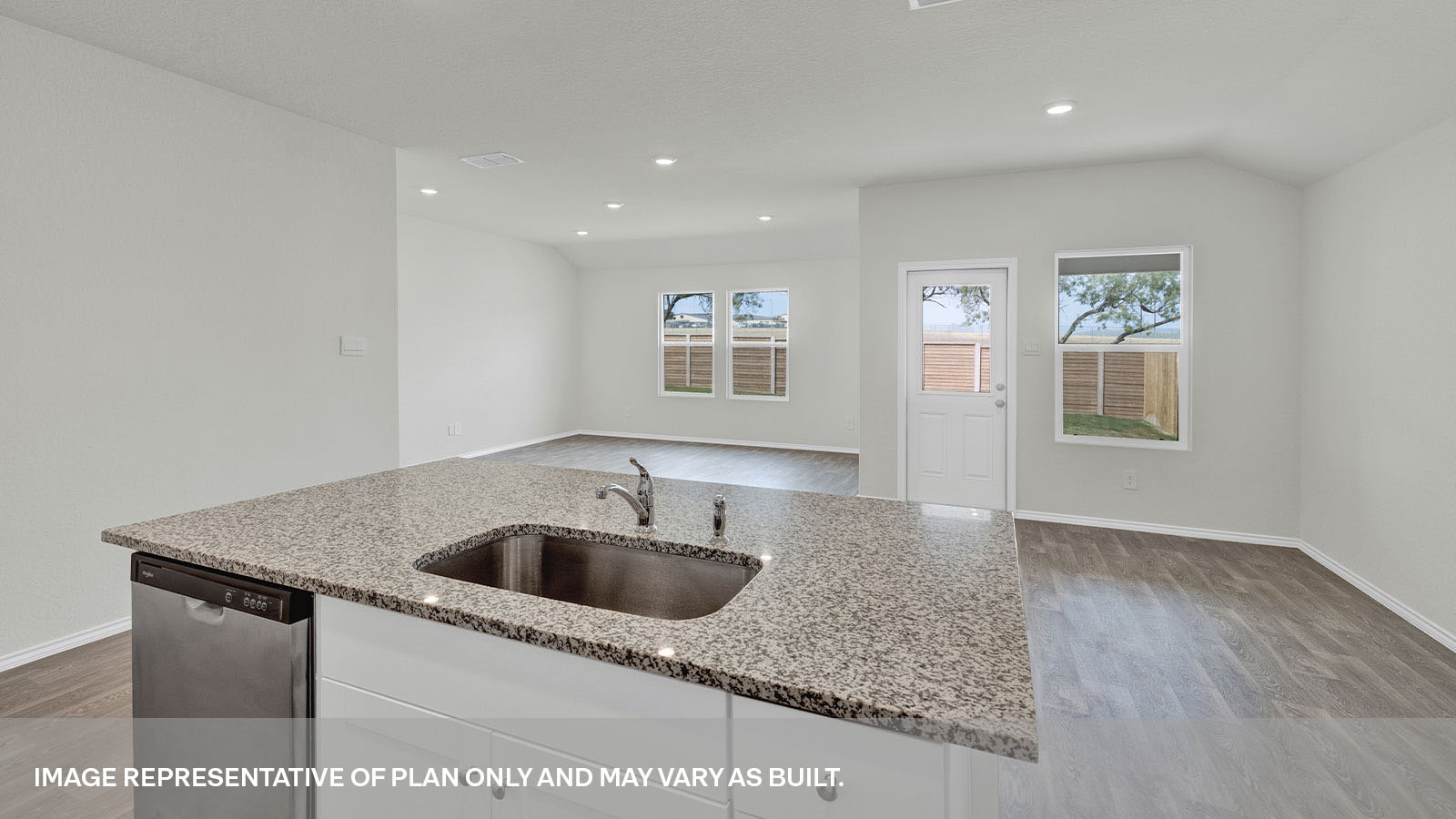 Kitchen with a kitchen island and large sink looking into the living room and dining area.