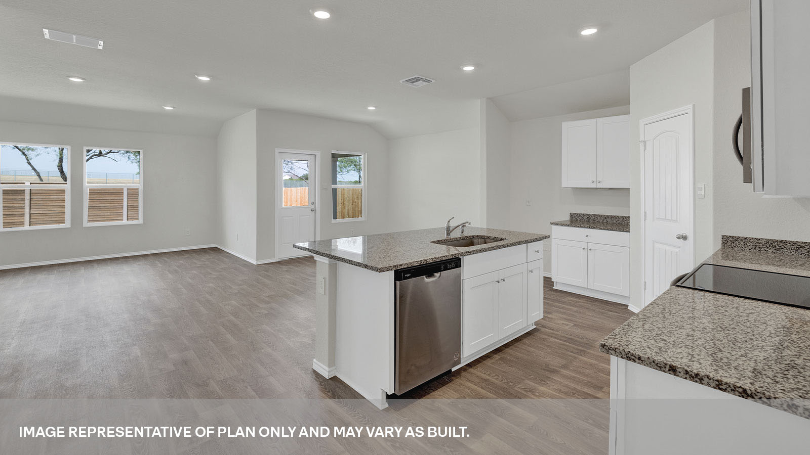 Kitchen with a kitchen island and large sink looking into the living room and dining area.