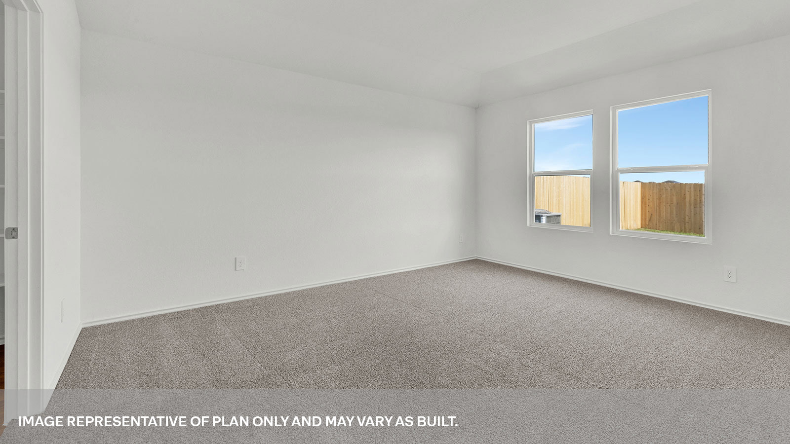 Main bedroom with carpet and two windows.