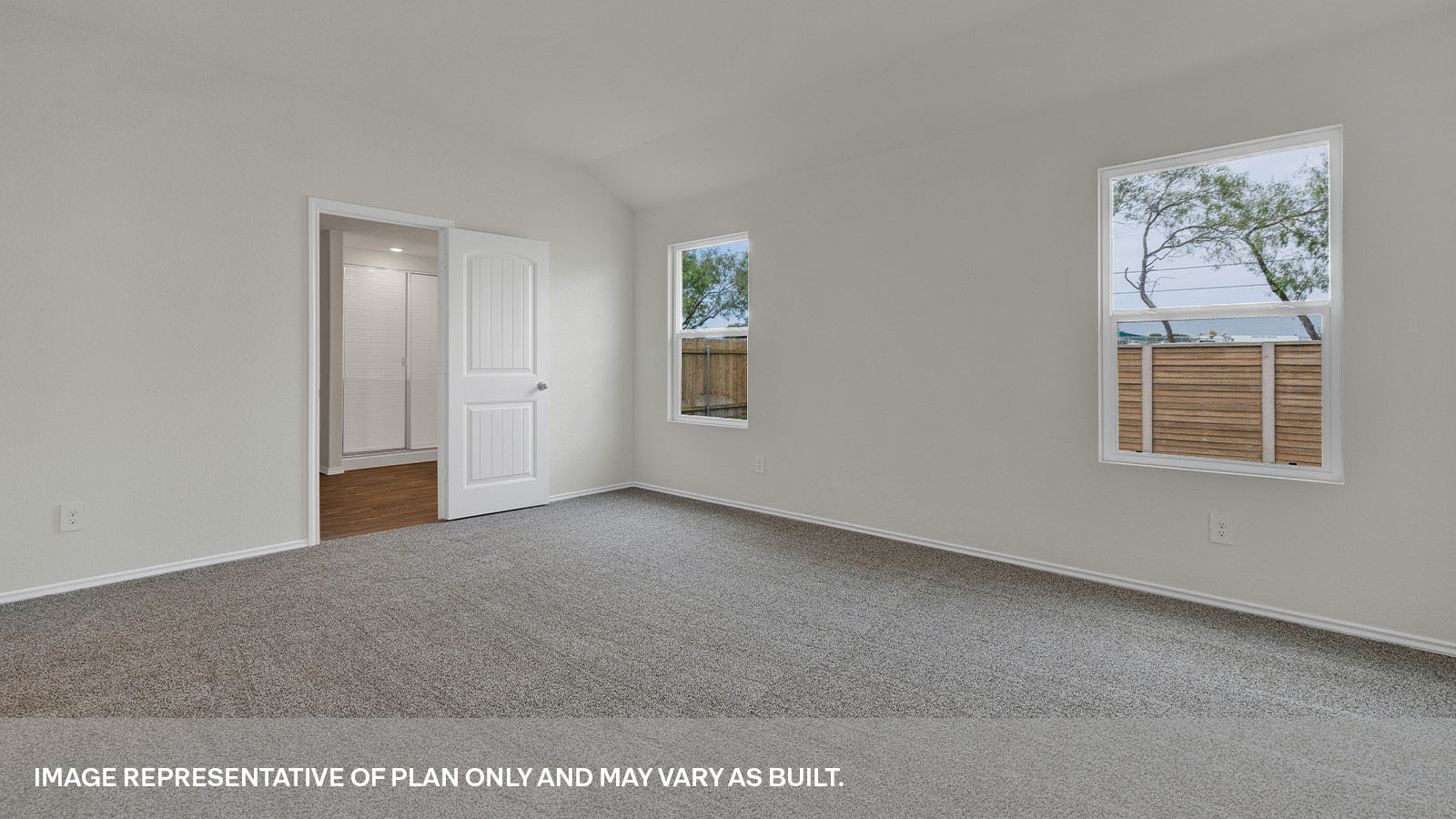 Main bedroom with carpet and two windows.