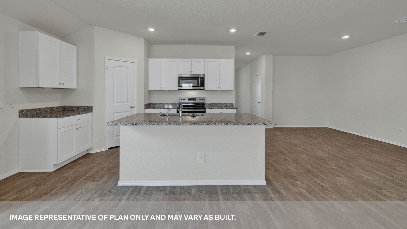 Kitchen with a kitchen island and large sink, pantry and appliances.
