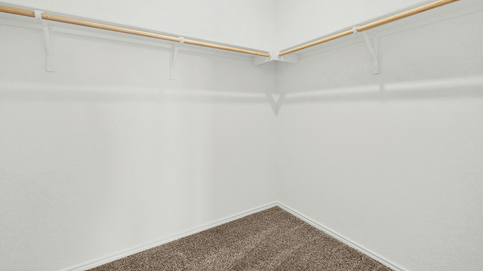 Main bedroom closet with carpeting and wooden shelving.