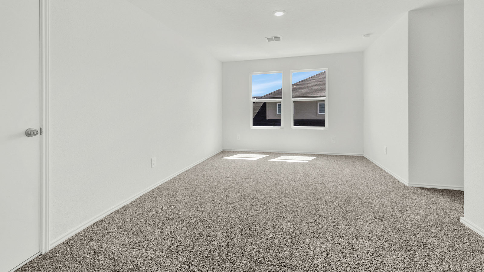 Loft with carpeting and windows.