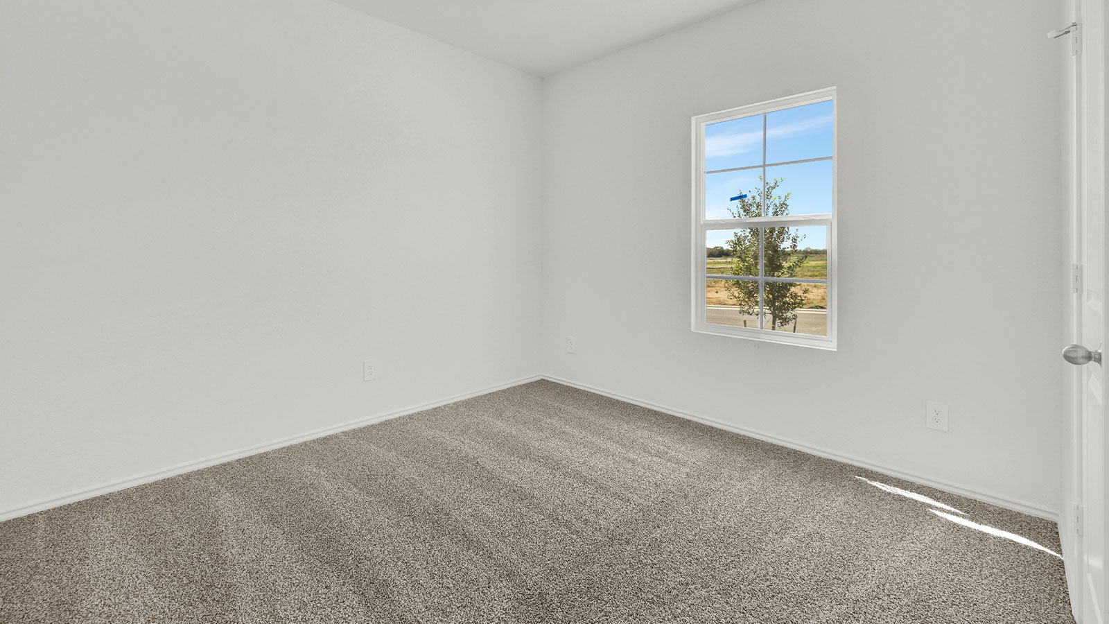 Front bedroom with carpeting and one window.
