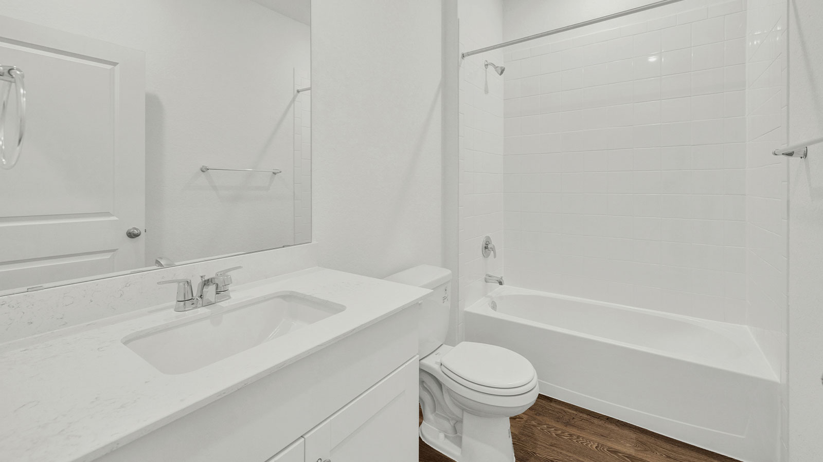 Hall bathroom with vanity, toilet, and tub with tile surround.