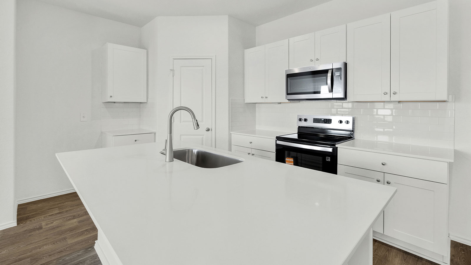 Kitchen with kitchen island, quartz countertops, and stainless steel appliances.