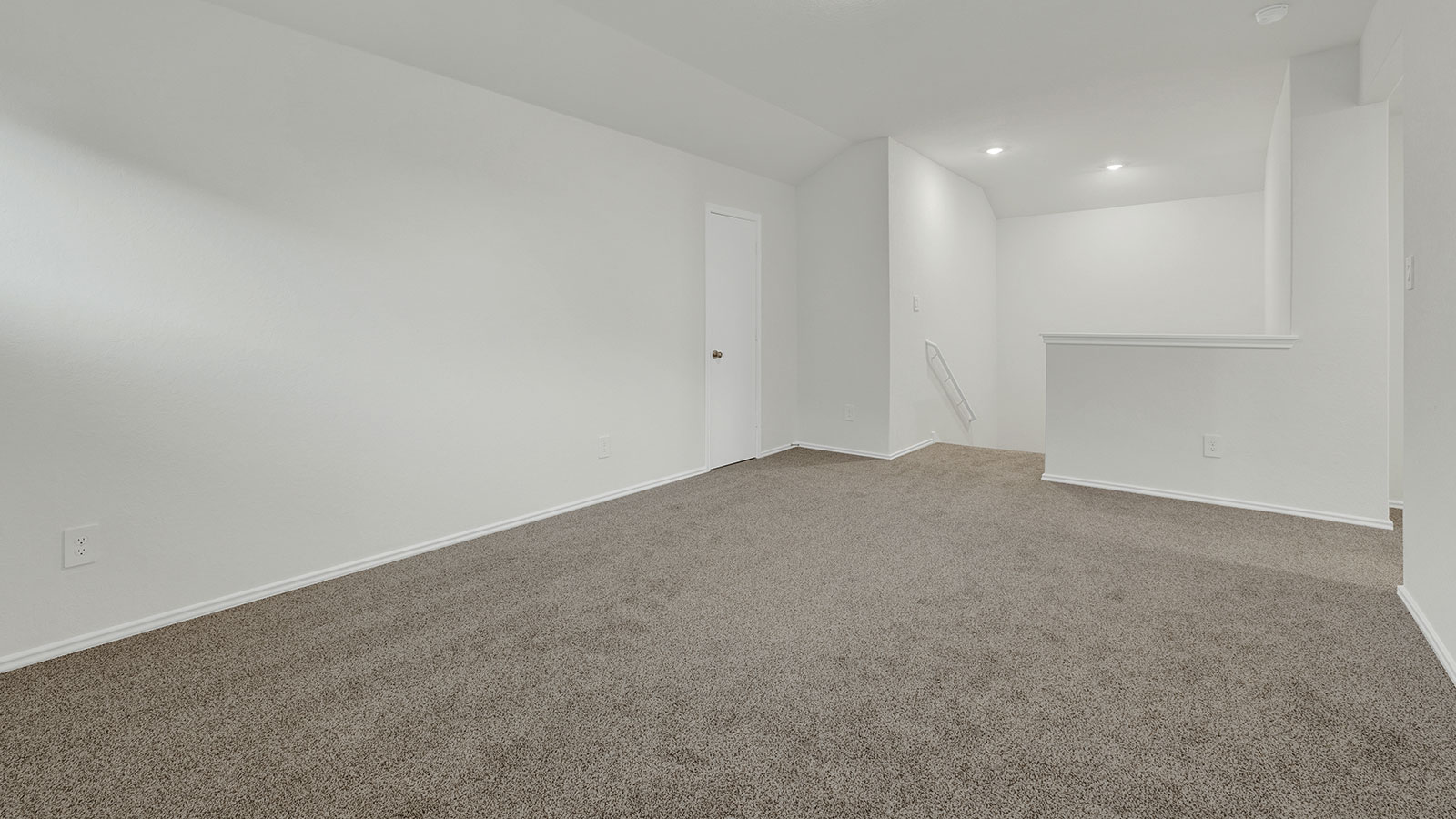 Gameroom off the staircase with carpeting.