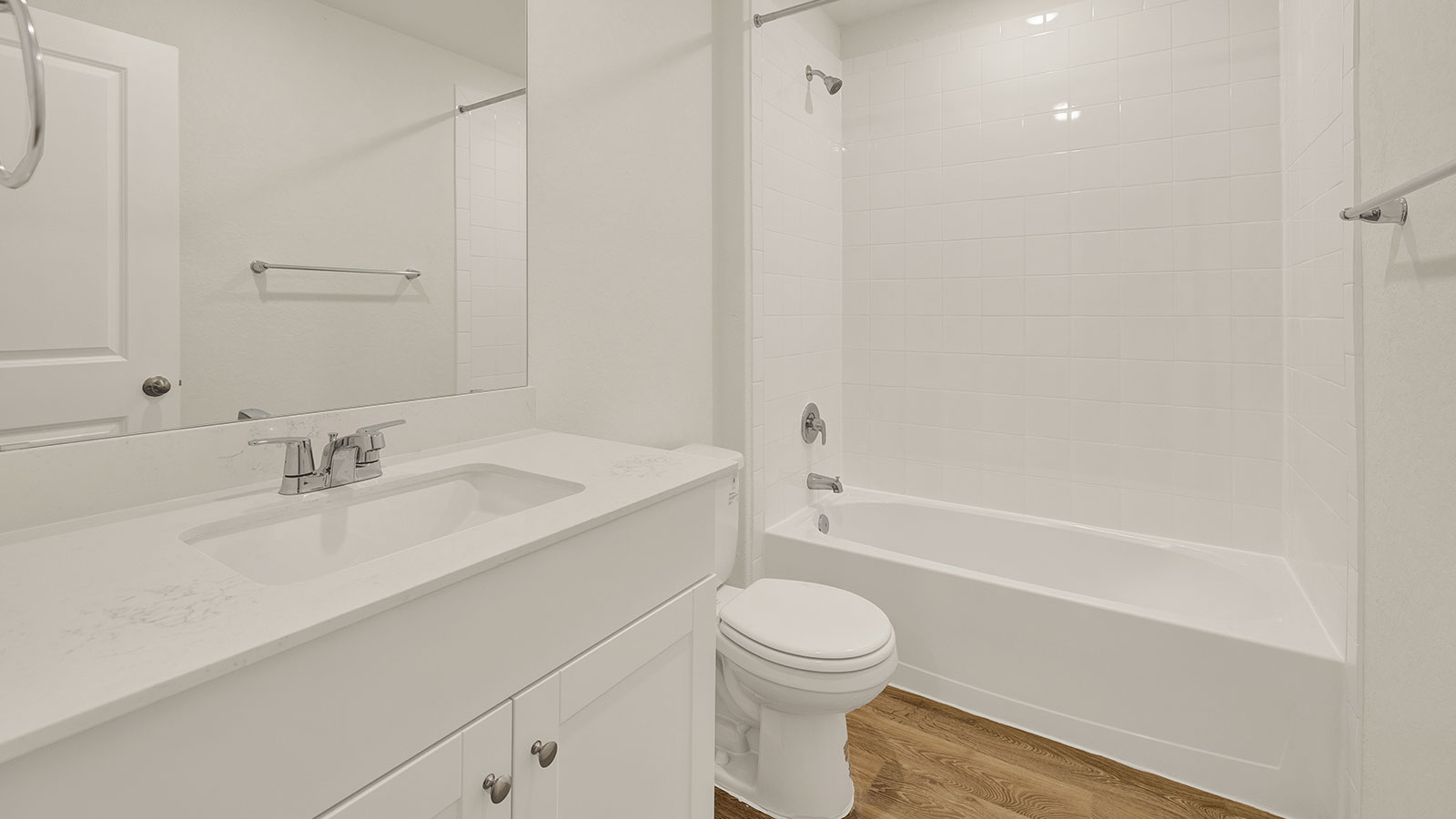 Hall bathroom with vanity, toilet, and tub with tile surround.