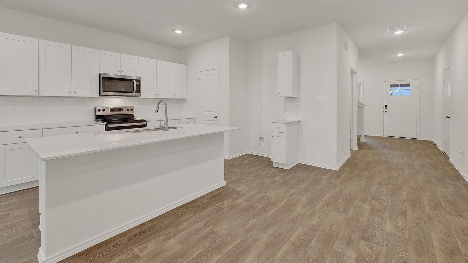 Entry hallway leading to the kitchen with kitchen island.