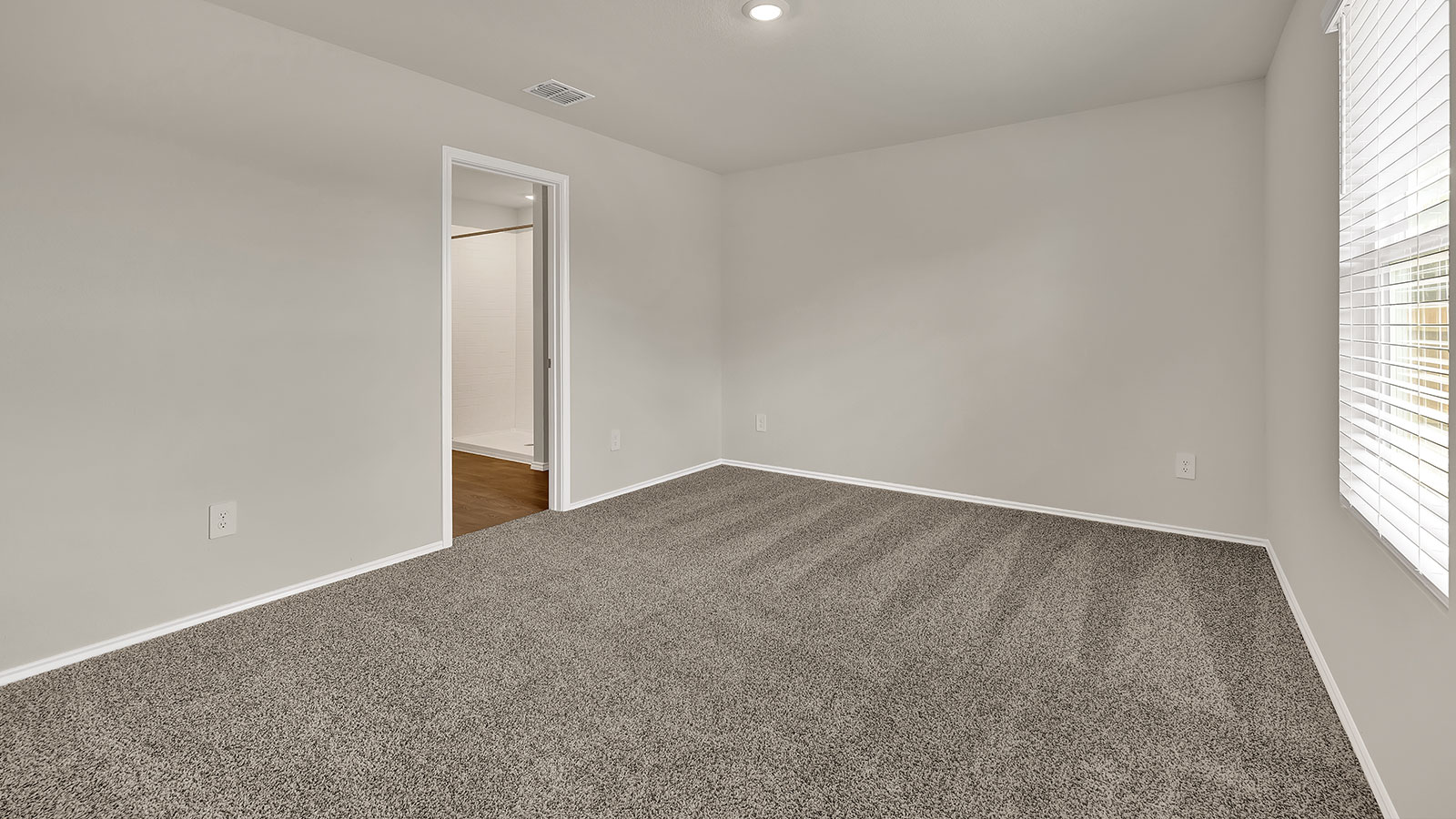 Main bedroom with carpeting and one window.