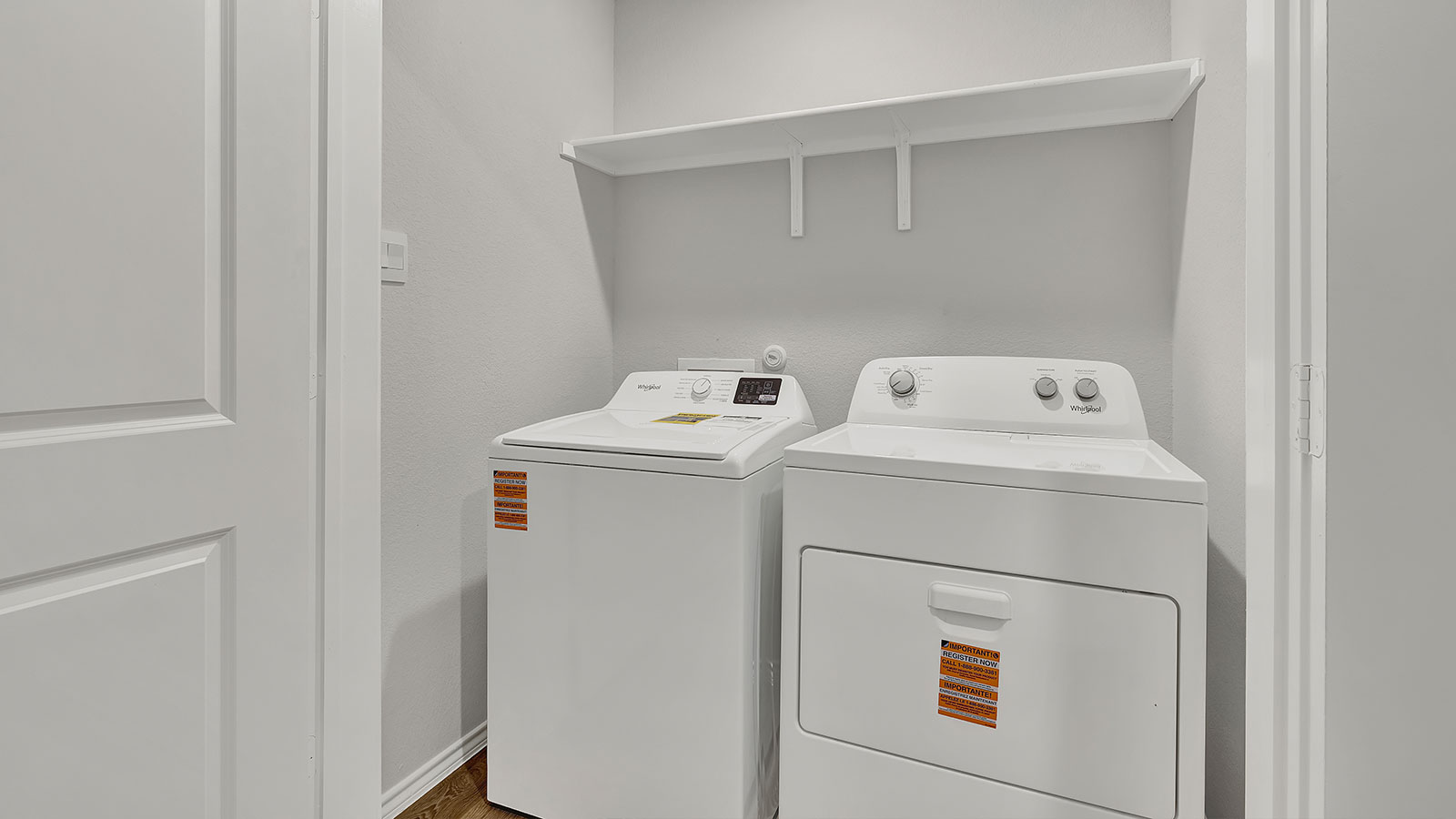 Laundry room with washer/dryer connections and wooden shelving.