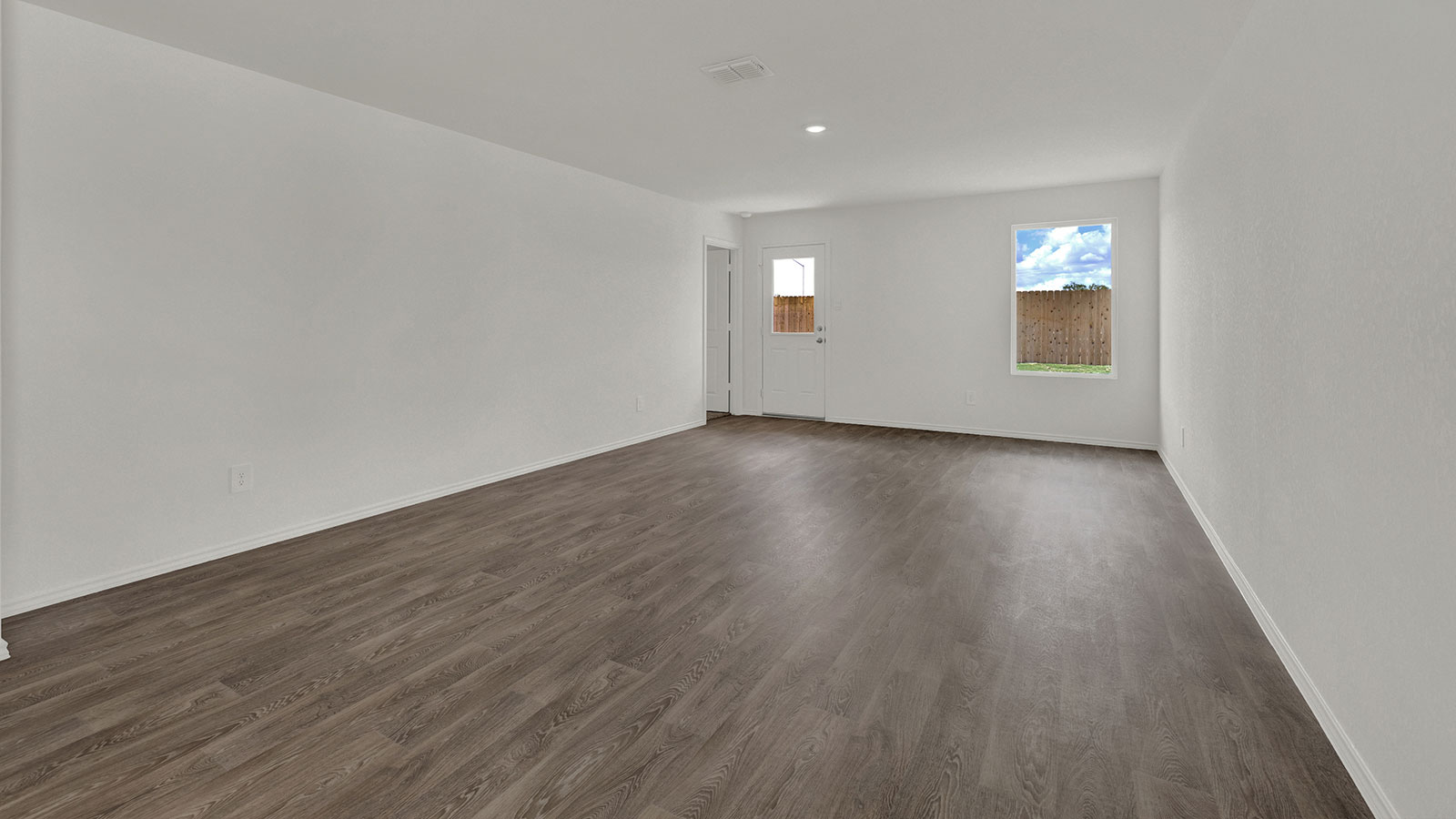 Living room with vinyl flooring, 2 windows, and  half lite exterior door.