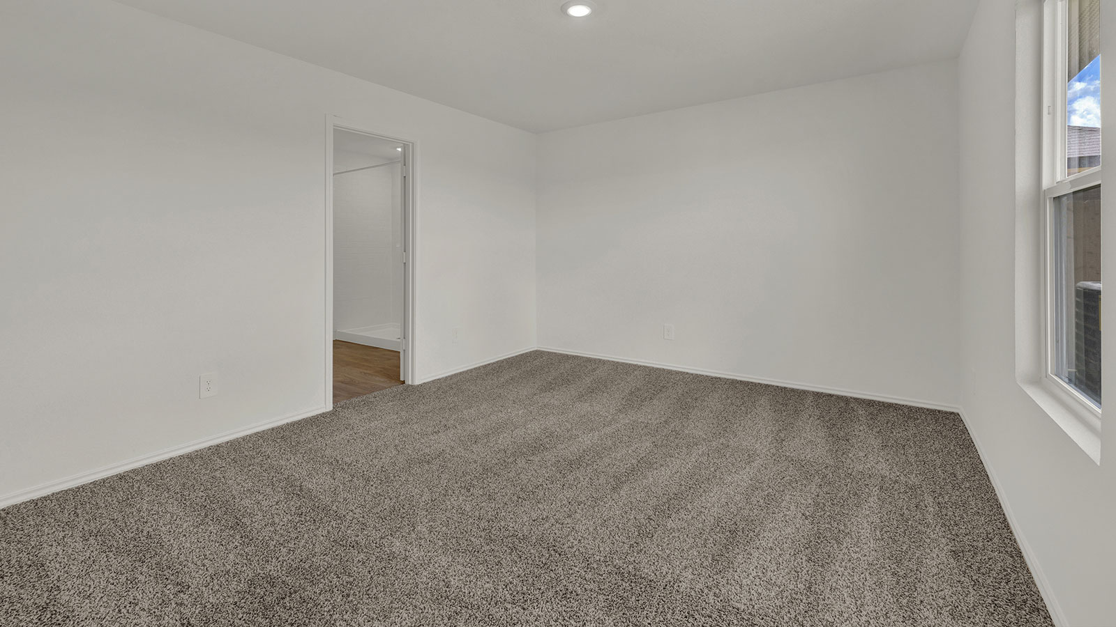 Main bedroom with carpeting and one window.