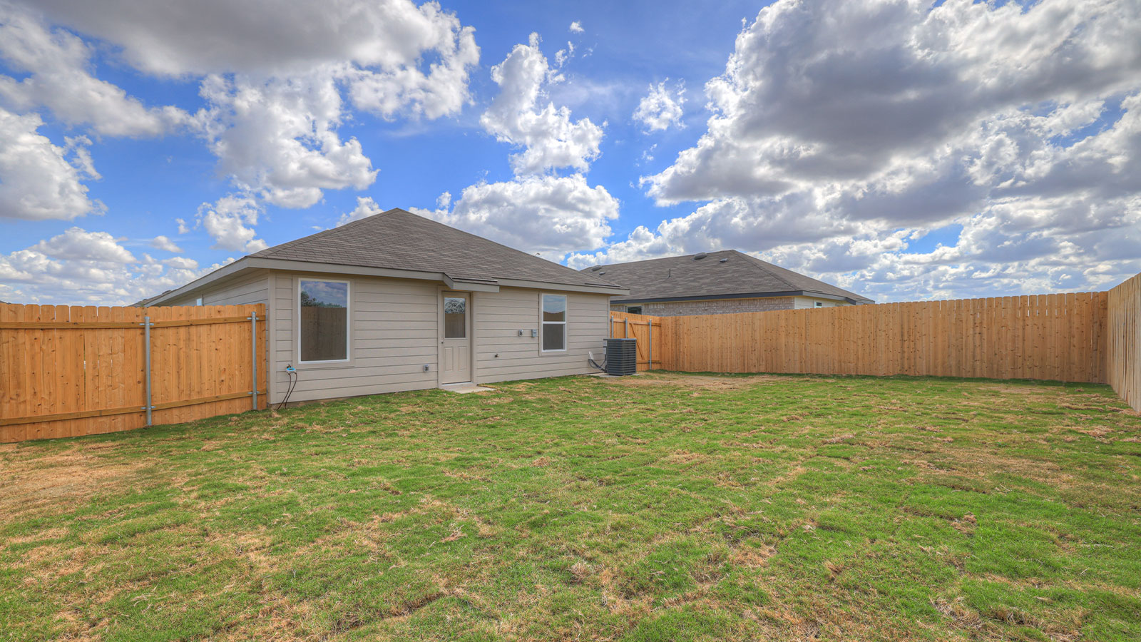 Backyard with sod and privacy fence.