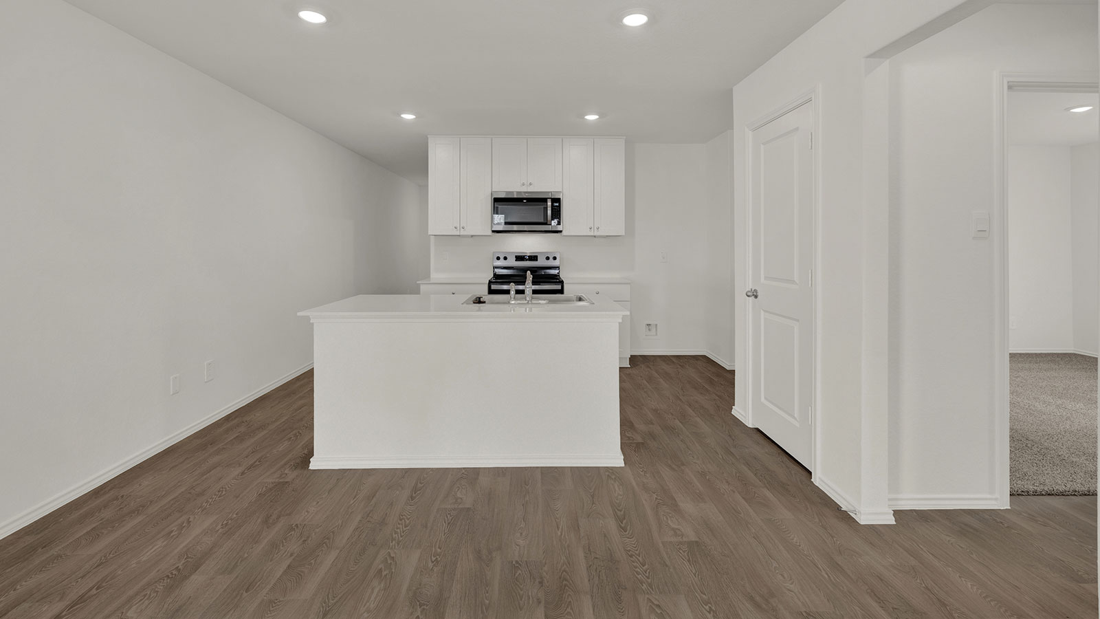 Kitchen with kitchen island and entry hallway.