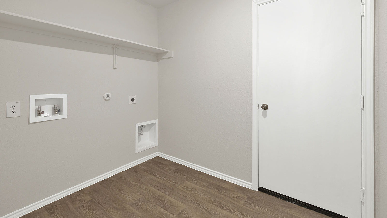 Laundry room with washer/dryer connections and wooden shelving.
