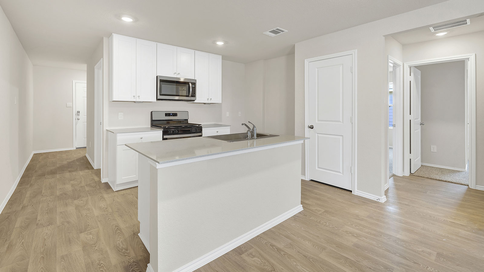 Entry hallway leading to the kitchen with kitchen island.