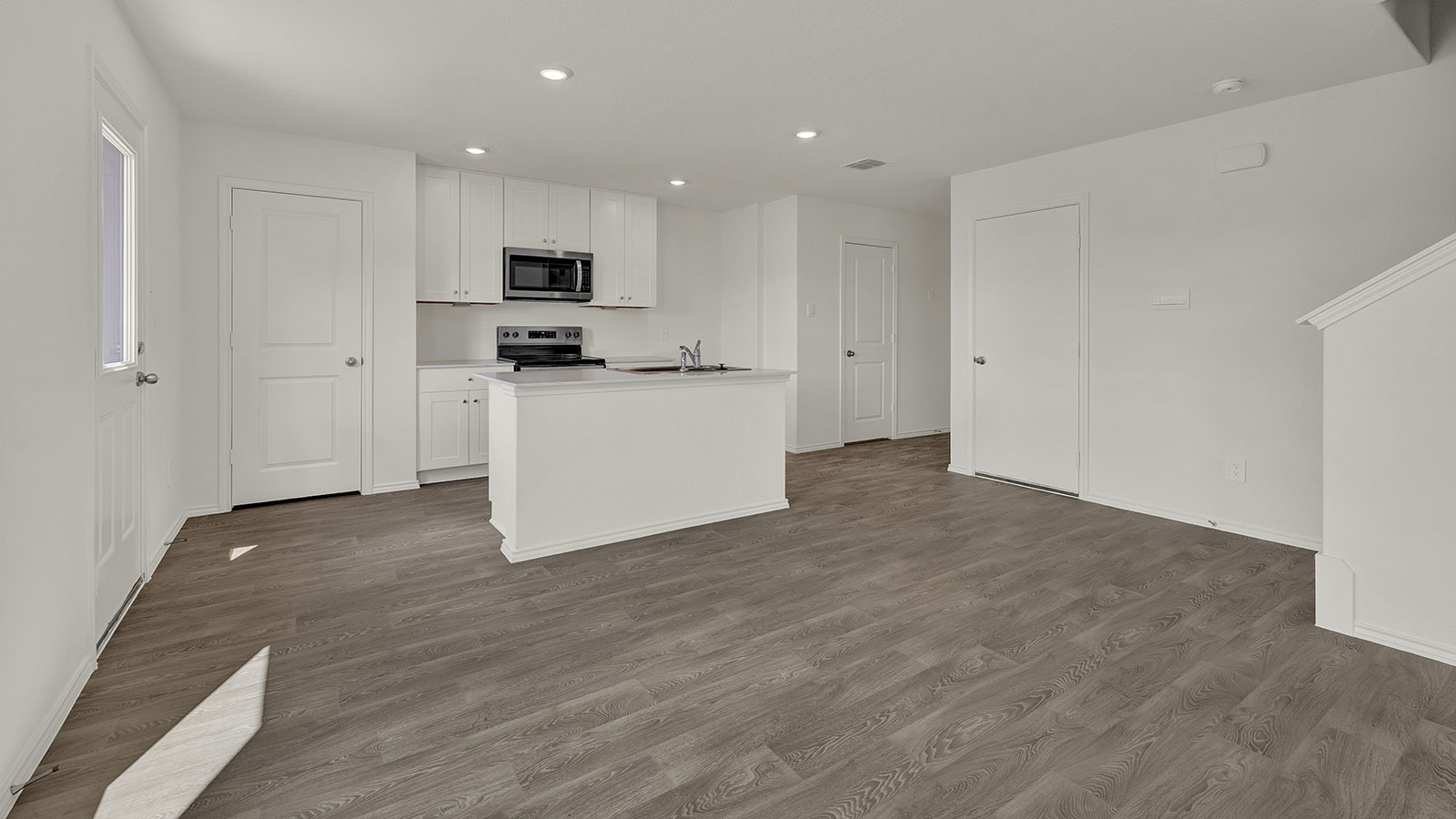 Living room with vinyl flooring opening to the kitchen.
