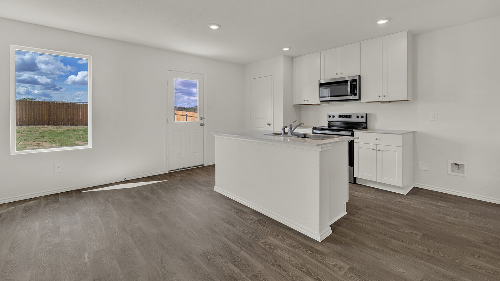 Dining room with vinyl flooring opening to the kitchen.