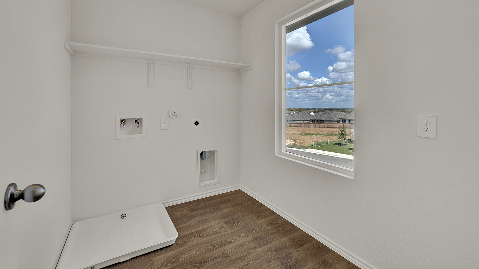 Laundry room with washer/dryer connections and wooden shelving.