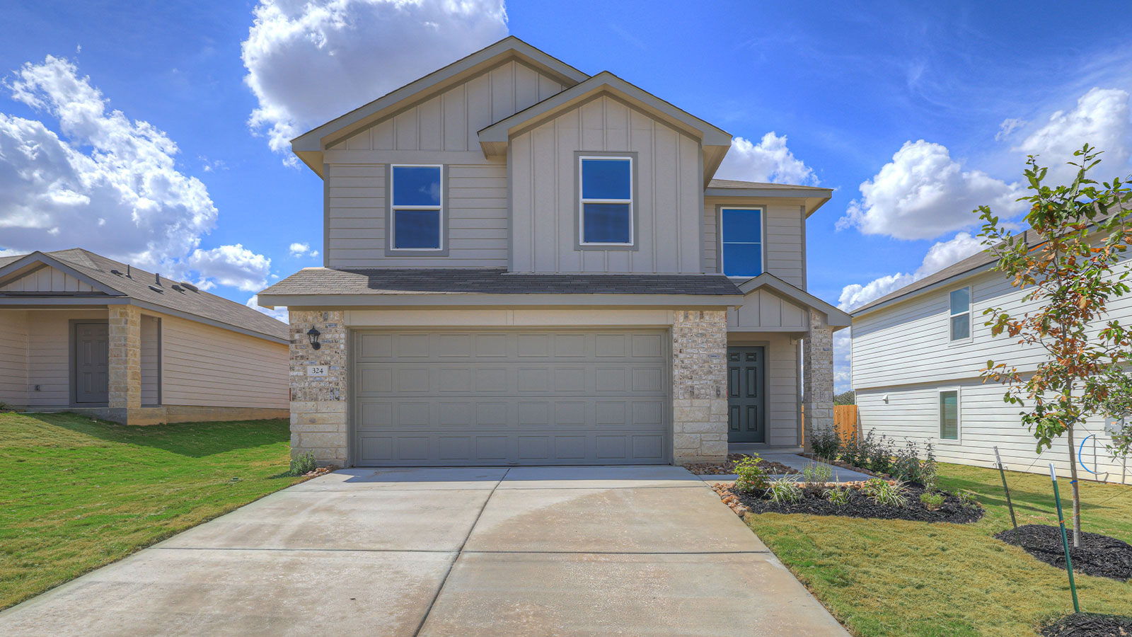 Two-story farmhouse exterior photo with 2 car garage.