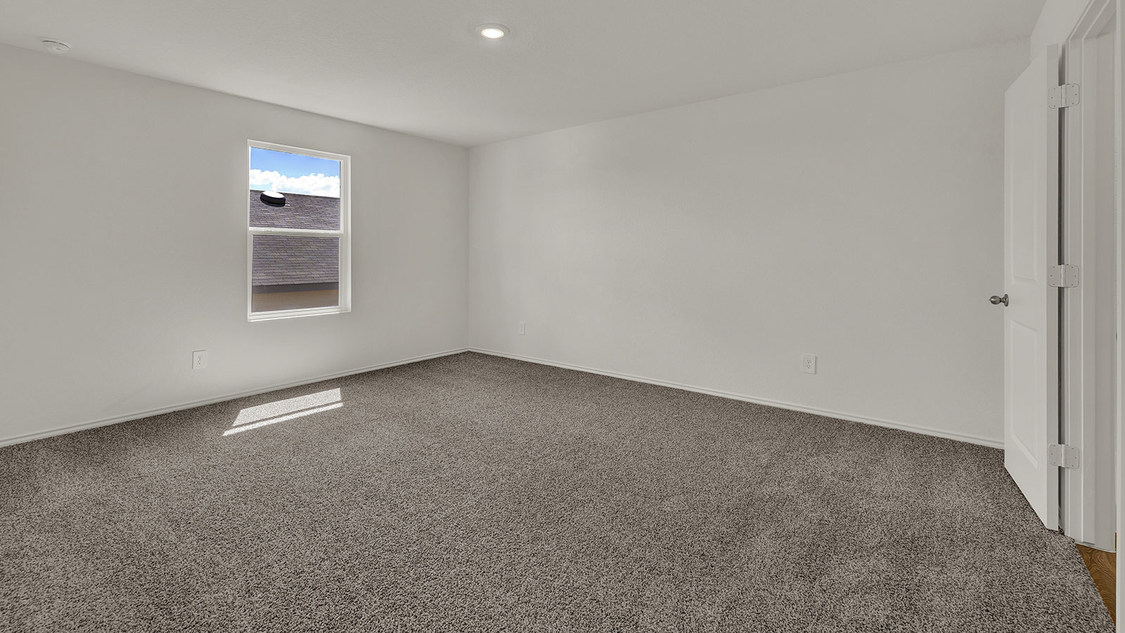 Main bedroom with carpeting and one window.