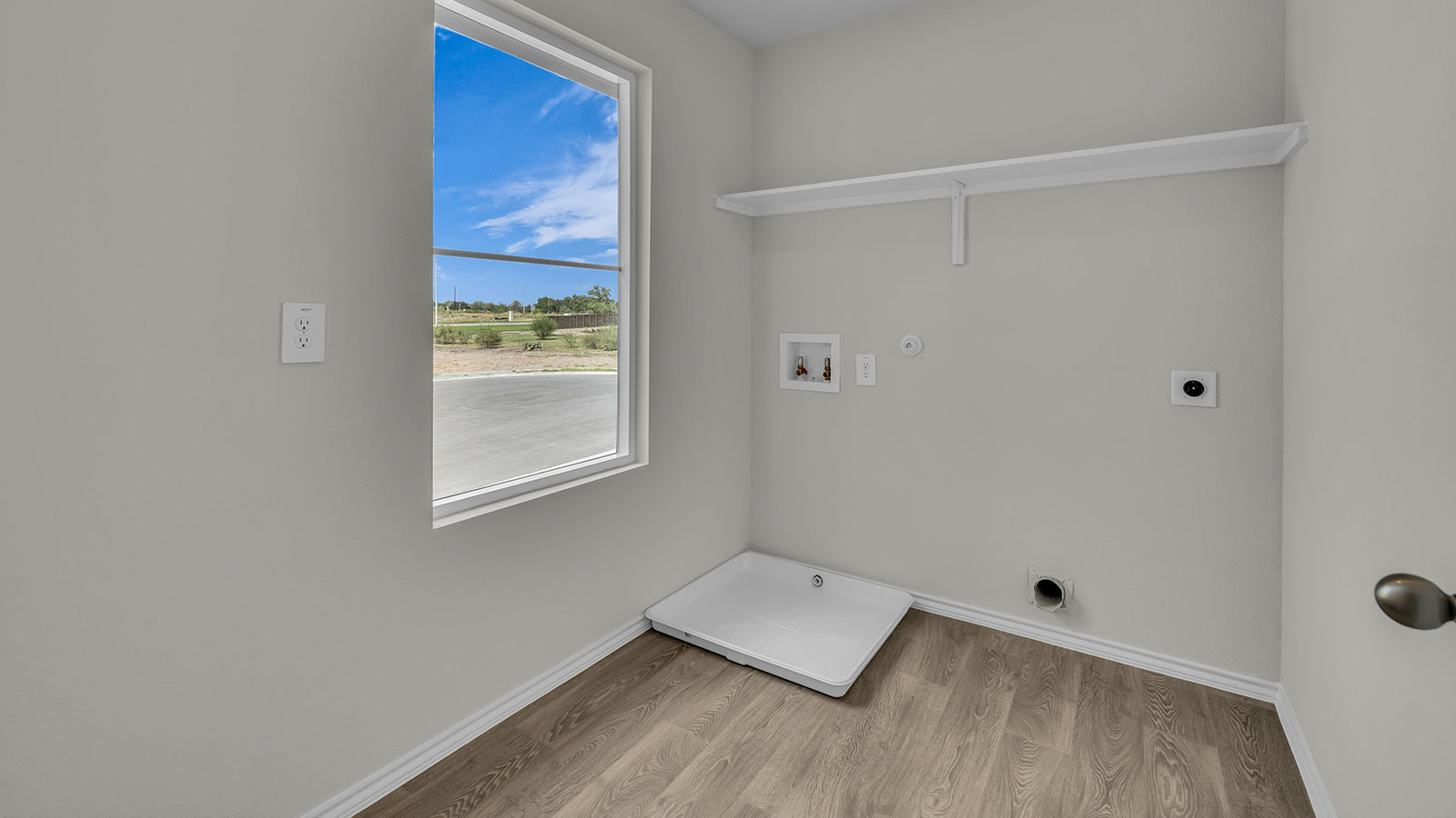 Laundry room with washer/dryer connections and wooden shelving.