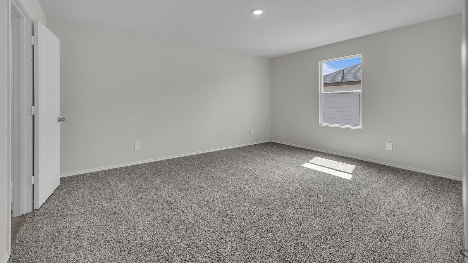 Main bedroom with carpeting and one window.