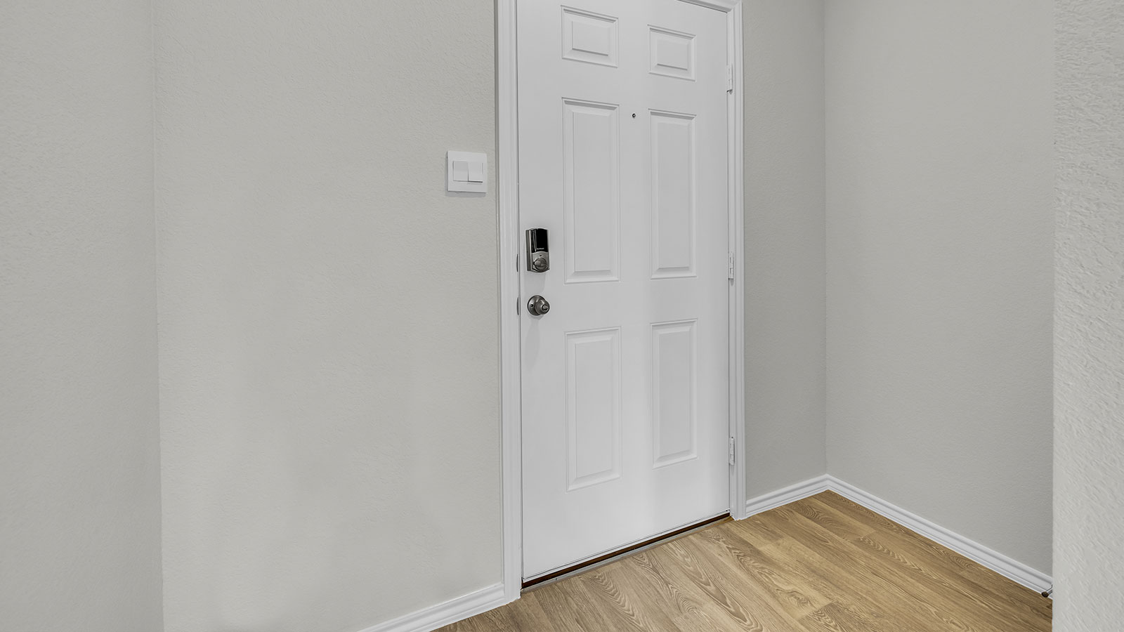 Entryway with vinyl flooring and front door.