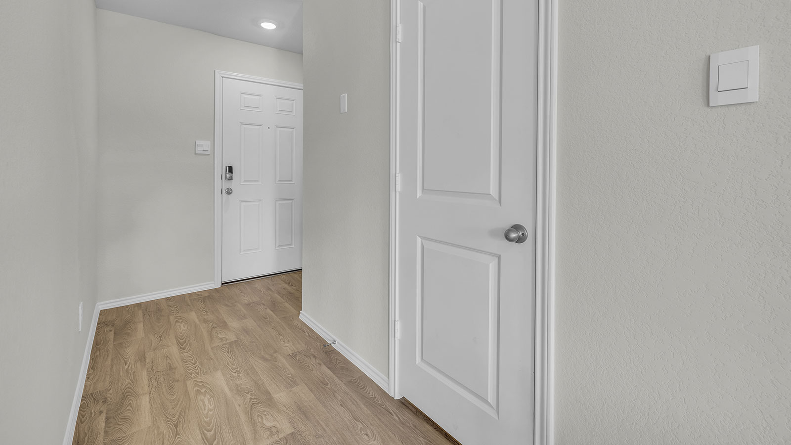 Entryway with vinyl flooring and front door.