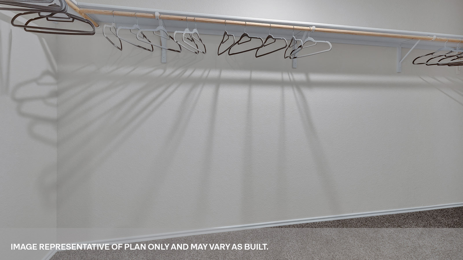 Main bedroom closet with carpeting and wooden shelving.