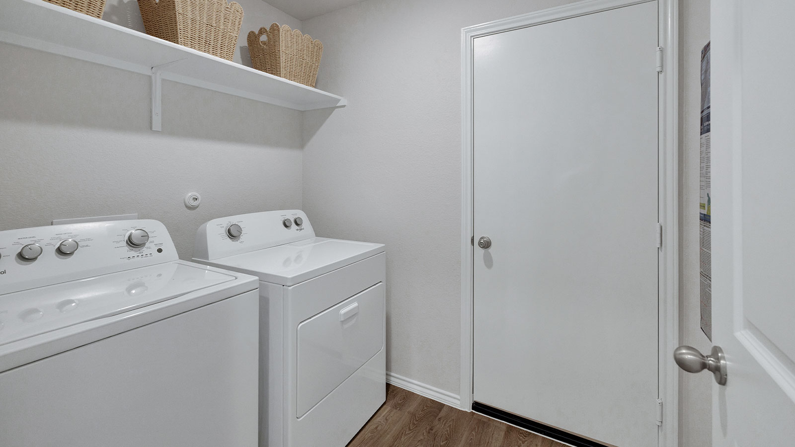 Laundry room with washer/dryer connections and wooden shelving.