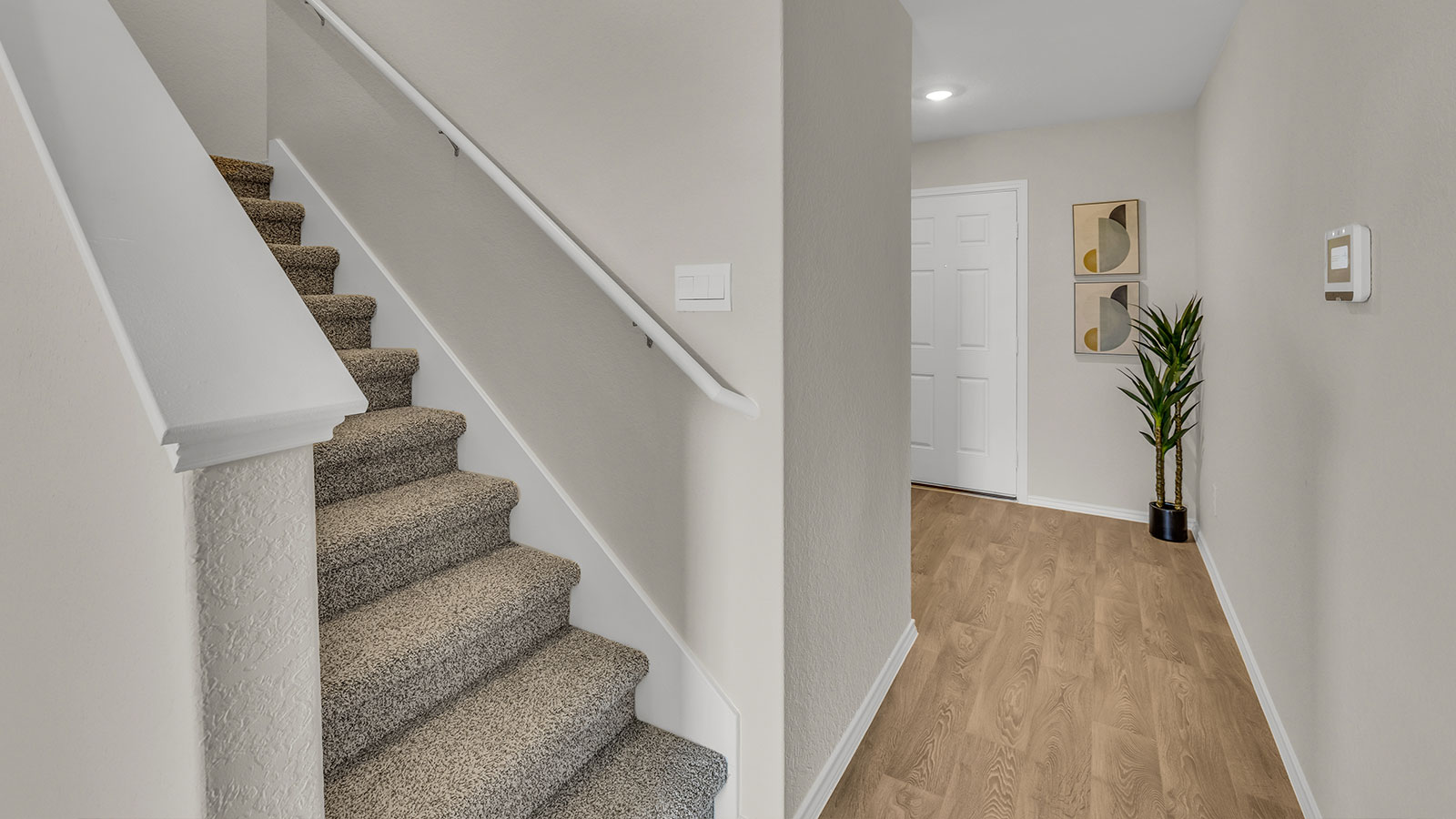 Entryway showing the front door and stairs with carpeting.