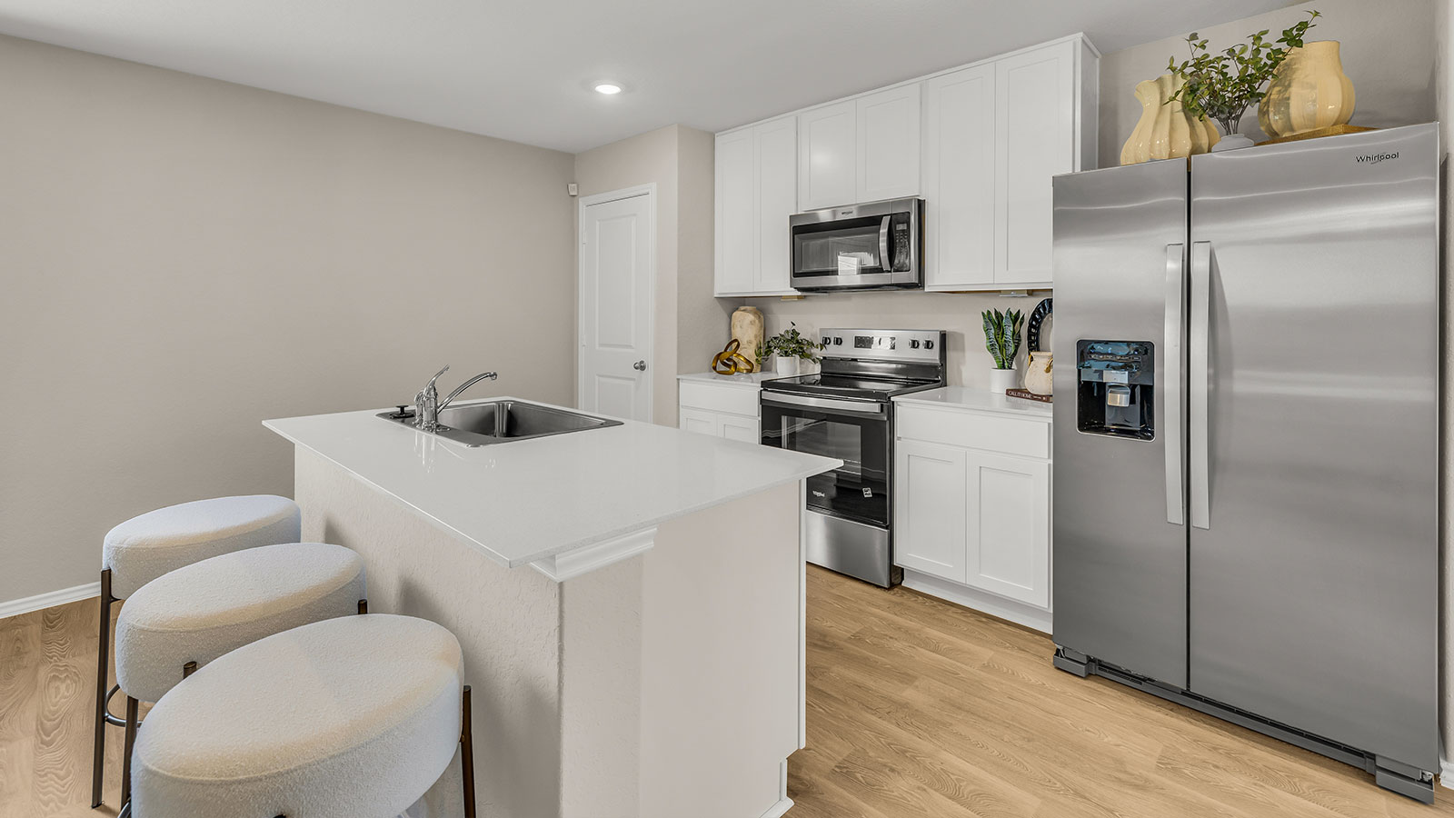 Kitchen island with quartz countertops and stainless steel appliances.