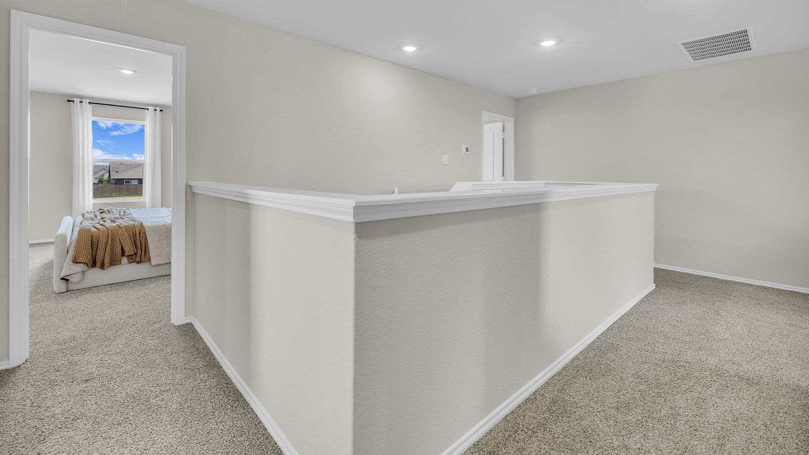 Bedroom hallway with carpeting leading to the main bedroom.