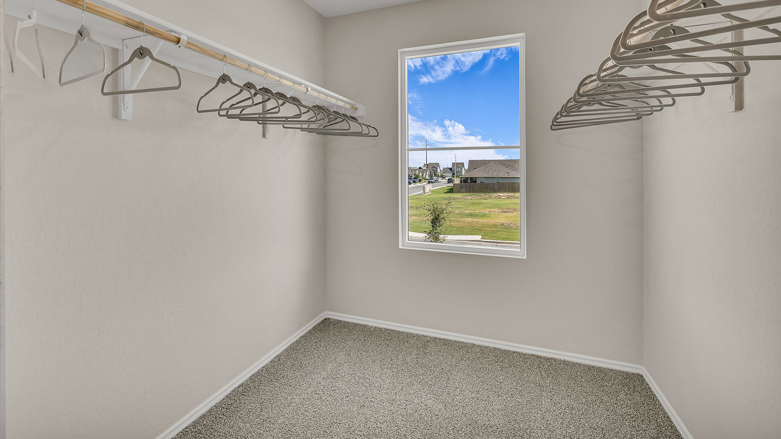 Main bedroom closet with carpeting and wooden shelving.