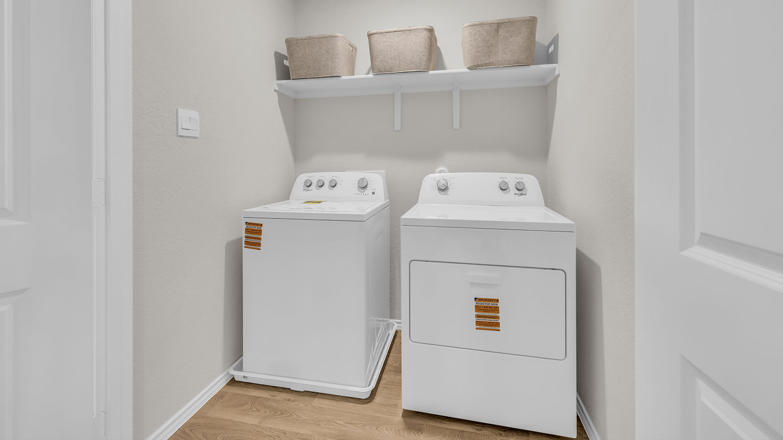 Laundry room with washer/dryer connections and wooden shelving.
