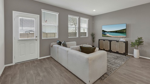 Living area with 3 windows and backdoor with a half-lite window.