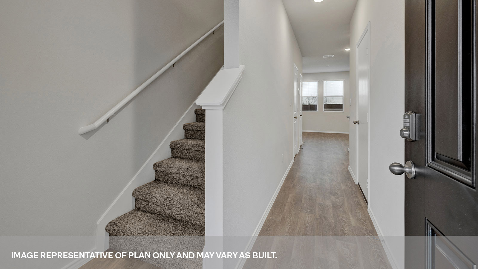 Entry hallway with vinyl flooring and a staircase leading towards the second floor.