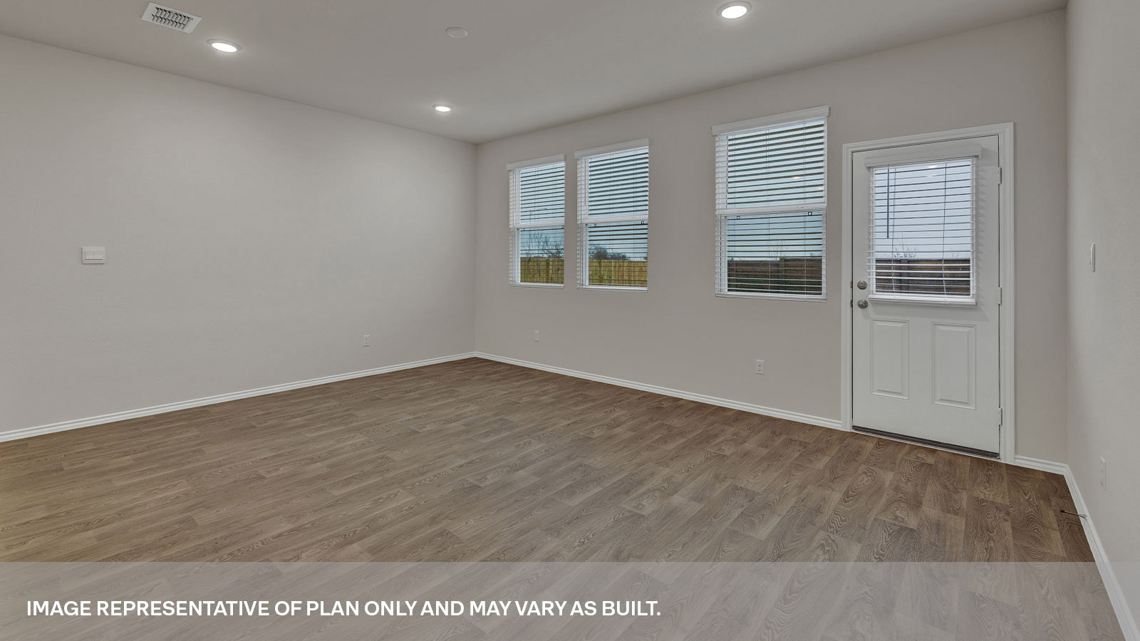 Dining area overlooking the living room, kitchen island, 3 windows and backdoor with a half-lite window.