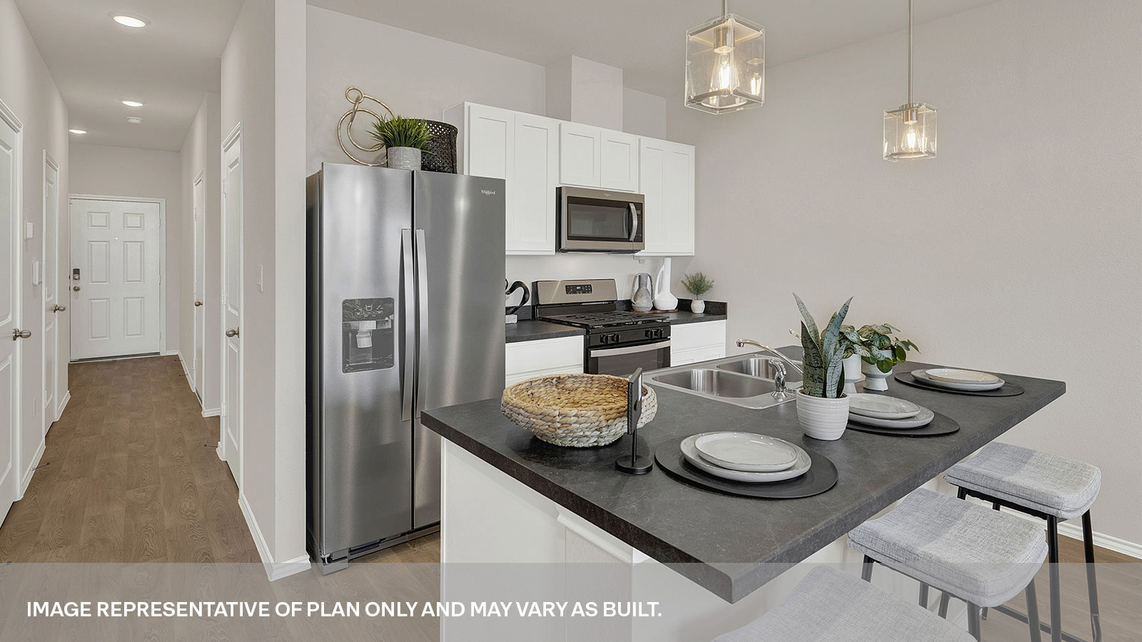 Kitchen with kitchen island with white cabinets and entry hallway.