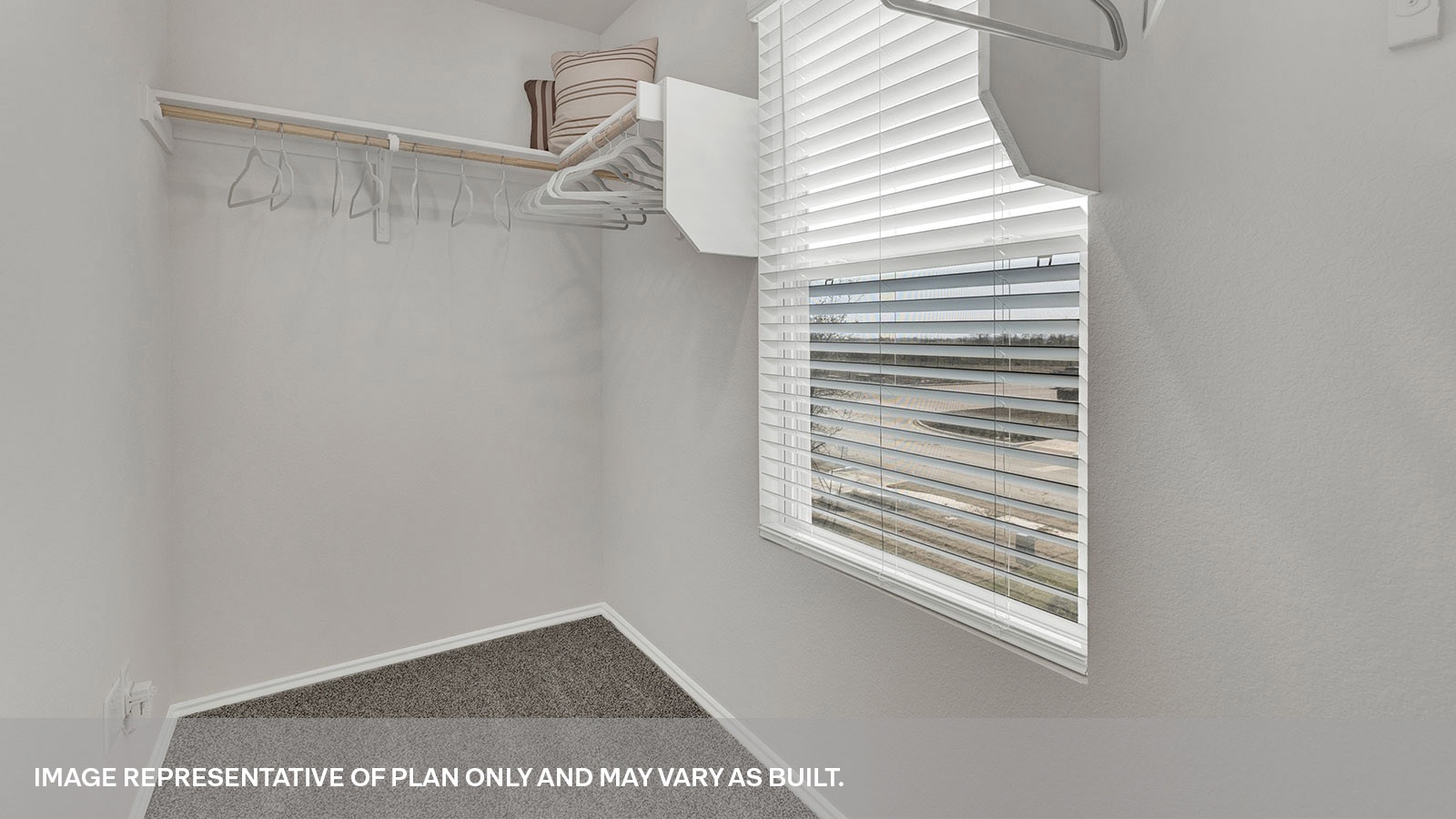 Large walk-in closet with wooden shelves and window.