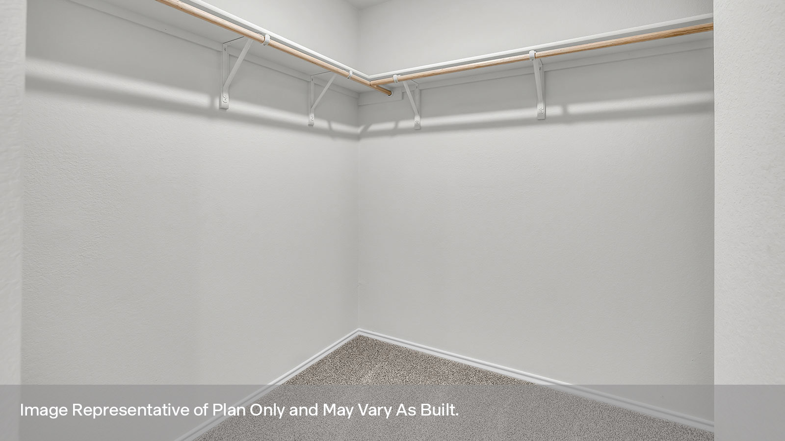 Main bedroom closet with carpeting and wooden shelving.