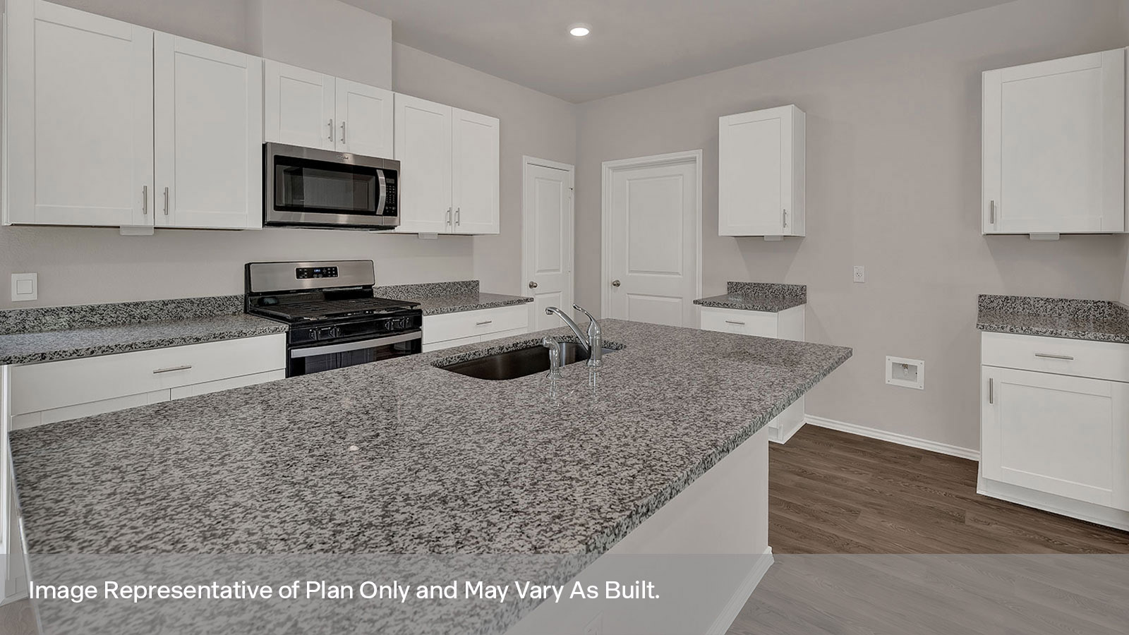 Kitchen island with granite countertops and white cabinets.