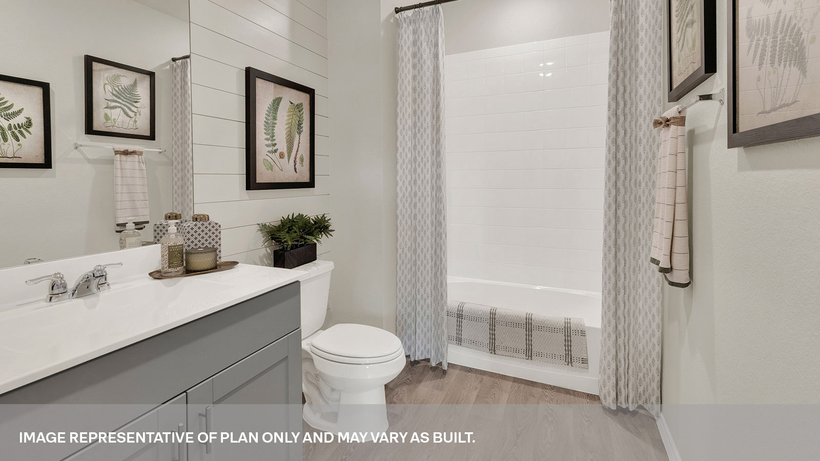 Hall bathroom with single sink vanity, toilet, and tub with tile surround.