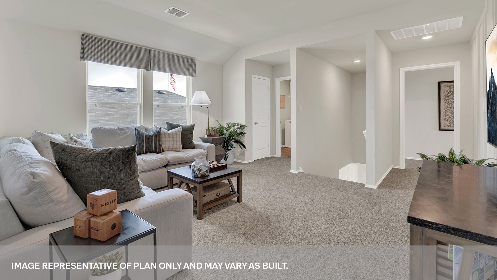 Gameroom of off the staircase with carpeting and two windows.