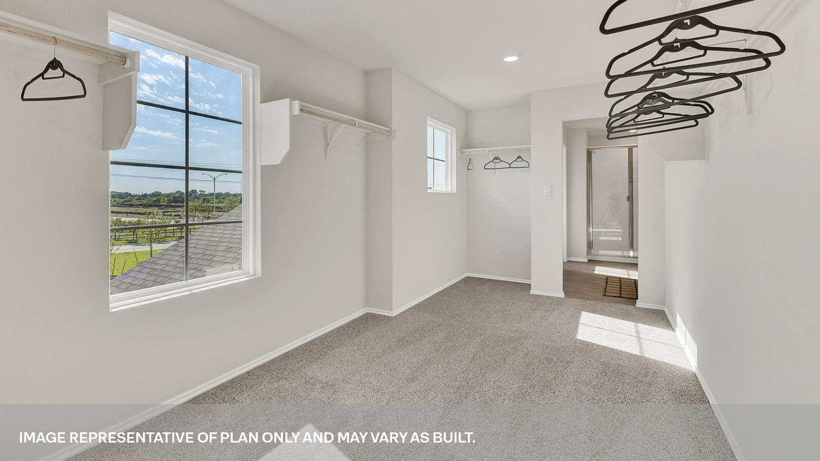Main bedroom closet with carpeting and wooden shelving.