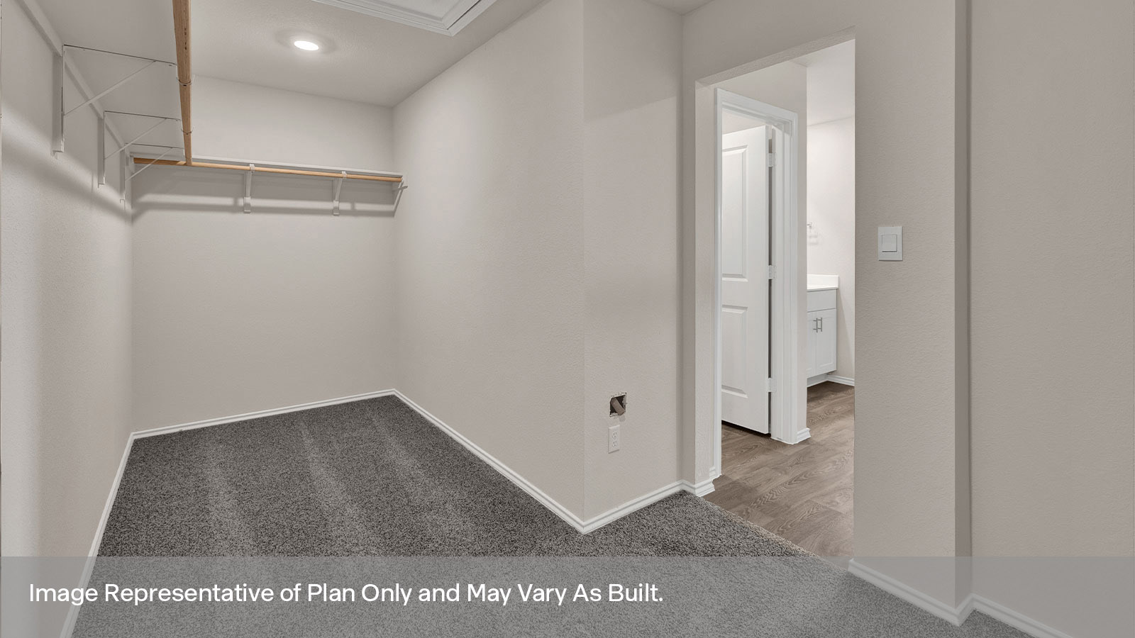 Main bedroom closet with carpeting and wooden shelving.
