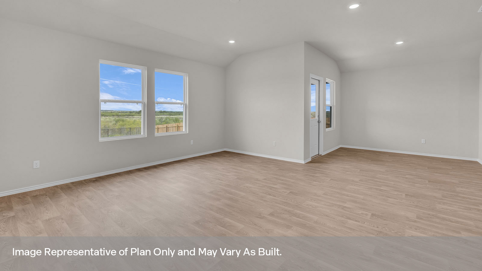 Dining area with 1 large window and a backdoor and living room with two large windows.
